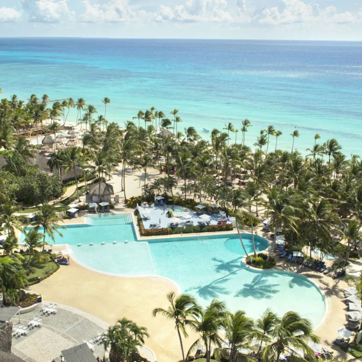 Catalonia Bayahibe’s large pool with palm trees and ocean views makes a perfect destination wedding spot.