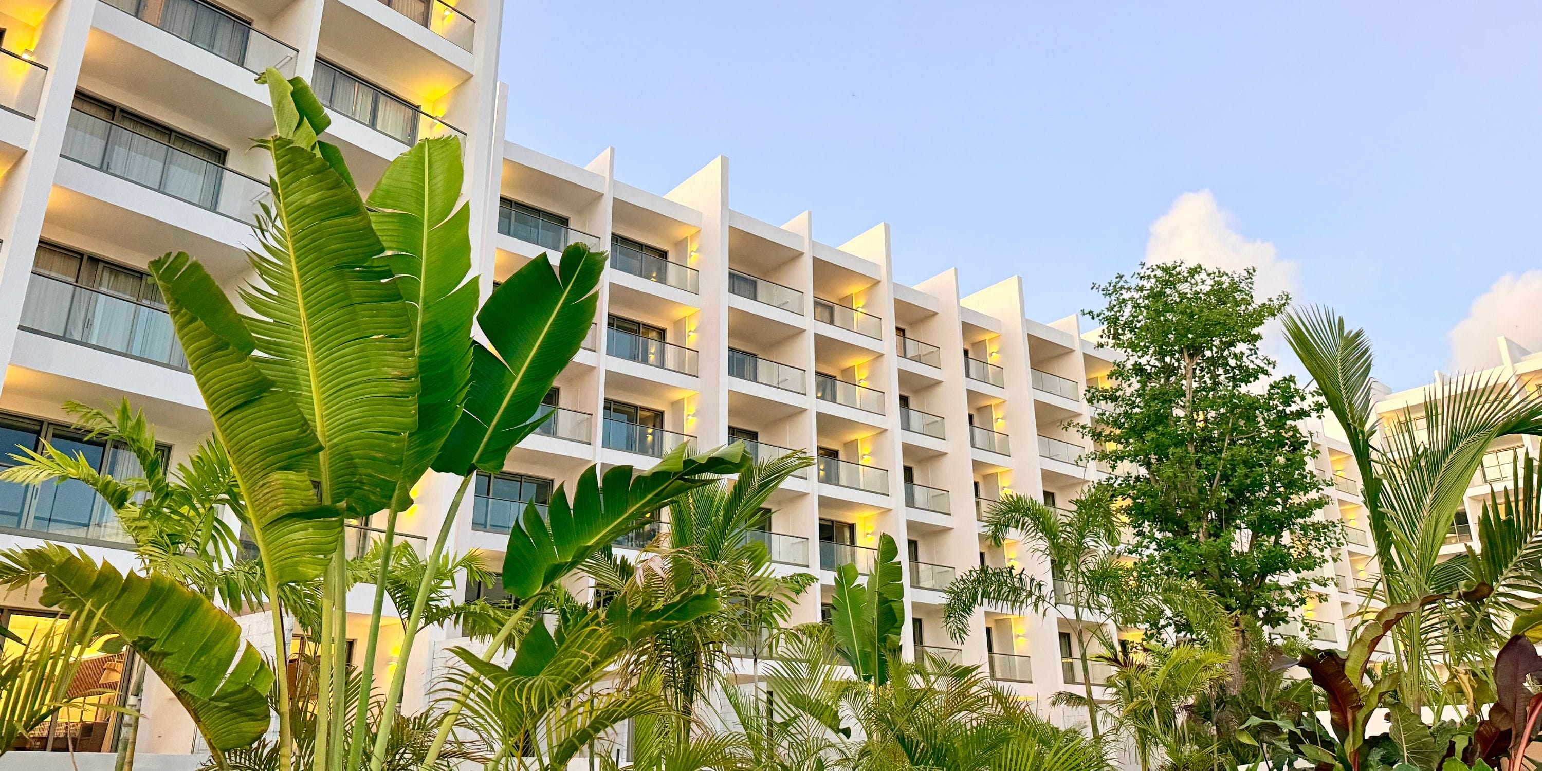 Royalton Vessence Barbados, a modern hotel with balconies, ideal for a destination wedding amid greenery.