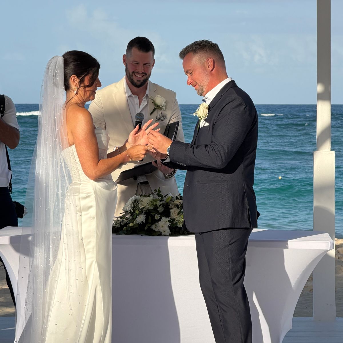 Hannah and Ben exchange rings at their beautiful oceanfront destination wedding ceremony.