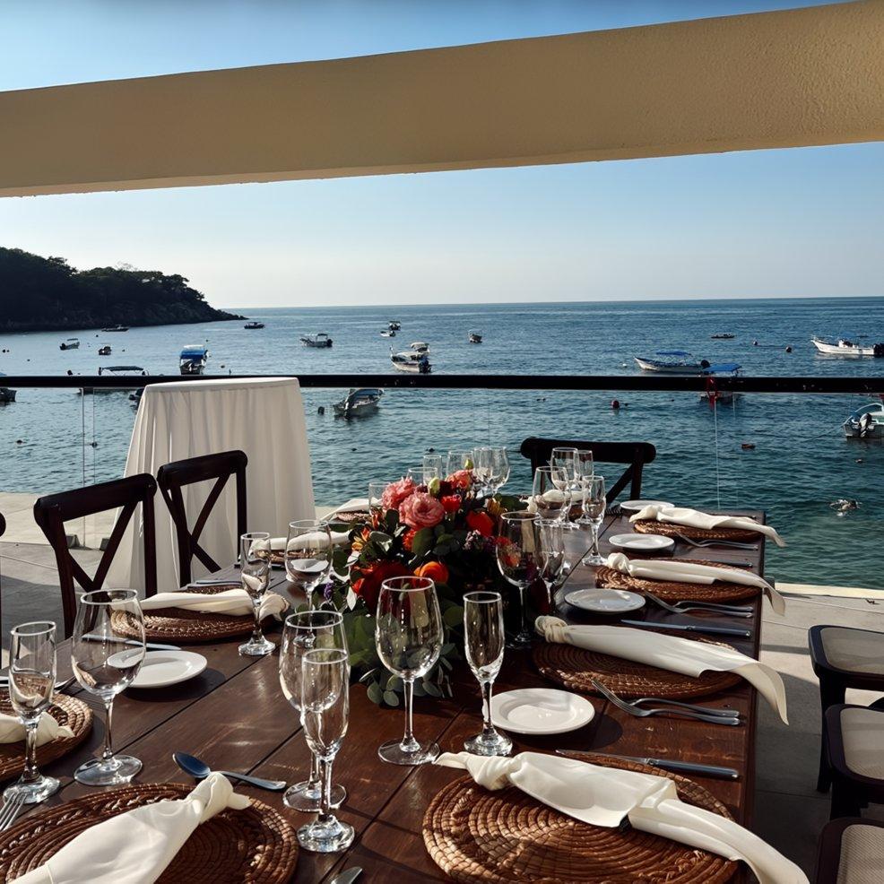 Elegant wedding table set on a terrace overlooking the ocean with boats, perfect for a destination wedding.