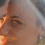 Close-up of a couple at their destination wedding, sunlight illuminating the bride’s face and veil.