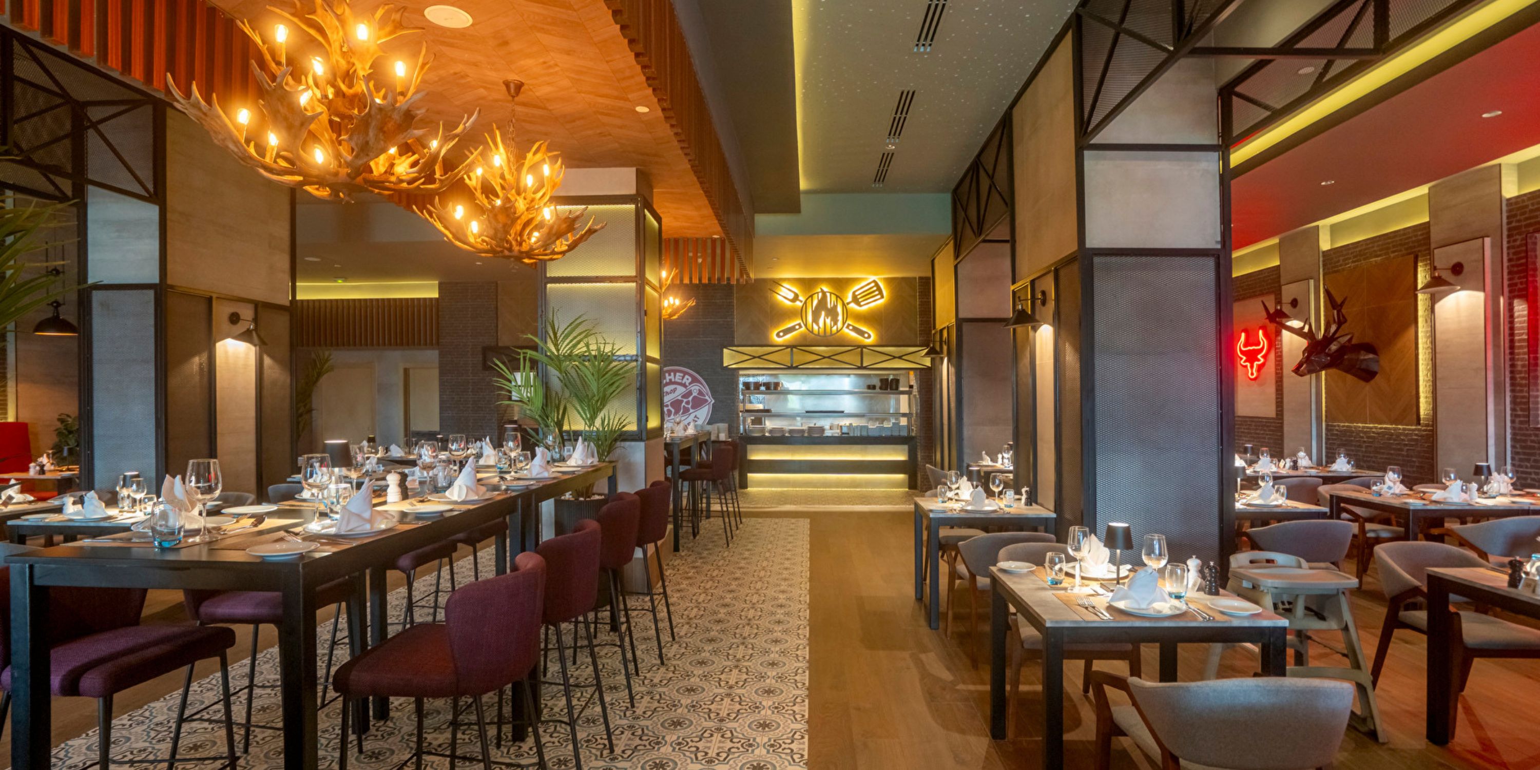 A dimly lit, modern space at Hotel Riu Jalisco, ideal for a destination wedding with antler chandeliers.