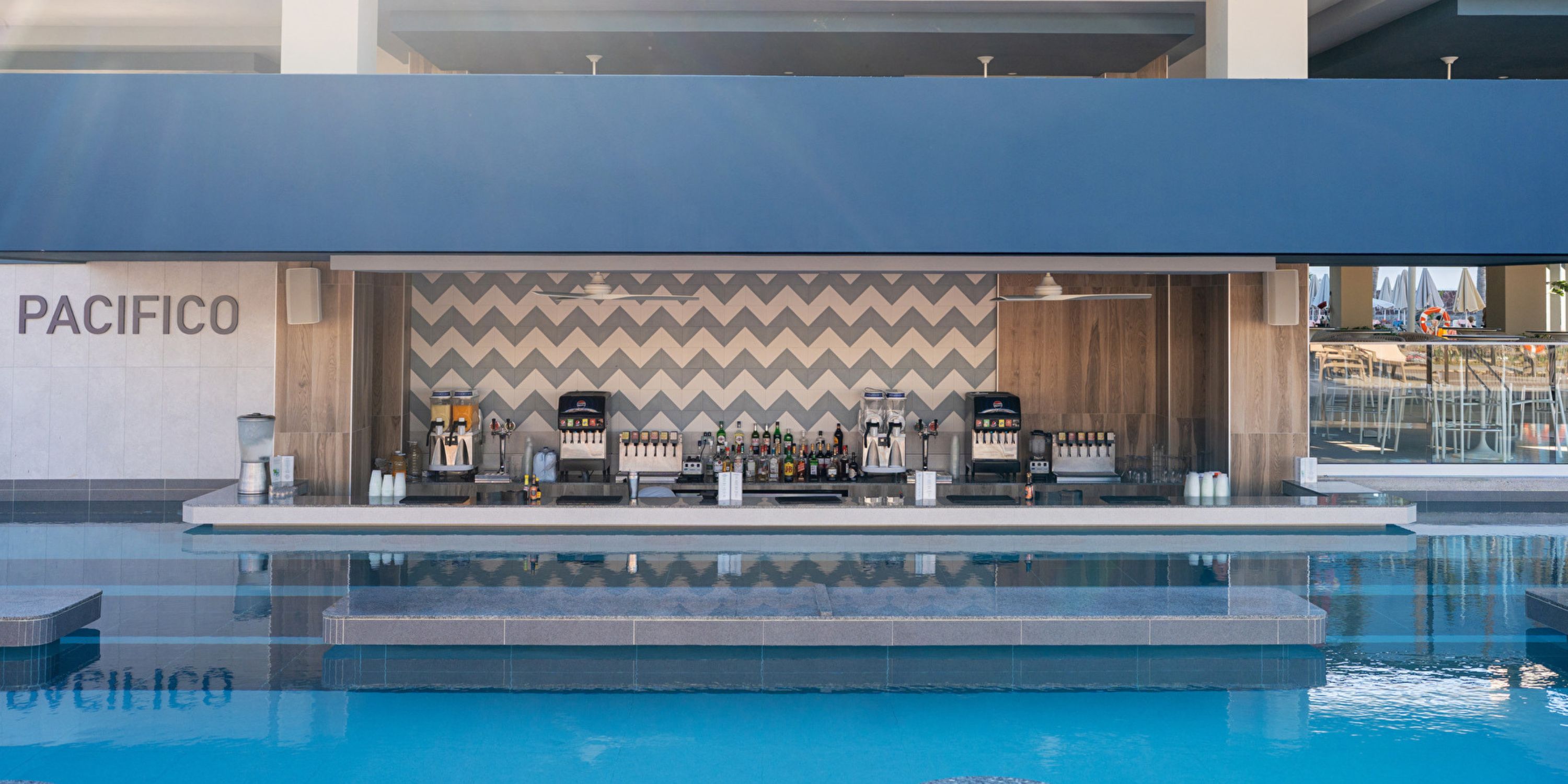 Swim-up bar with drinks and stools by the pool at Hotel Riu Jalisco, perfect for a destination wedding.