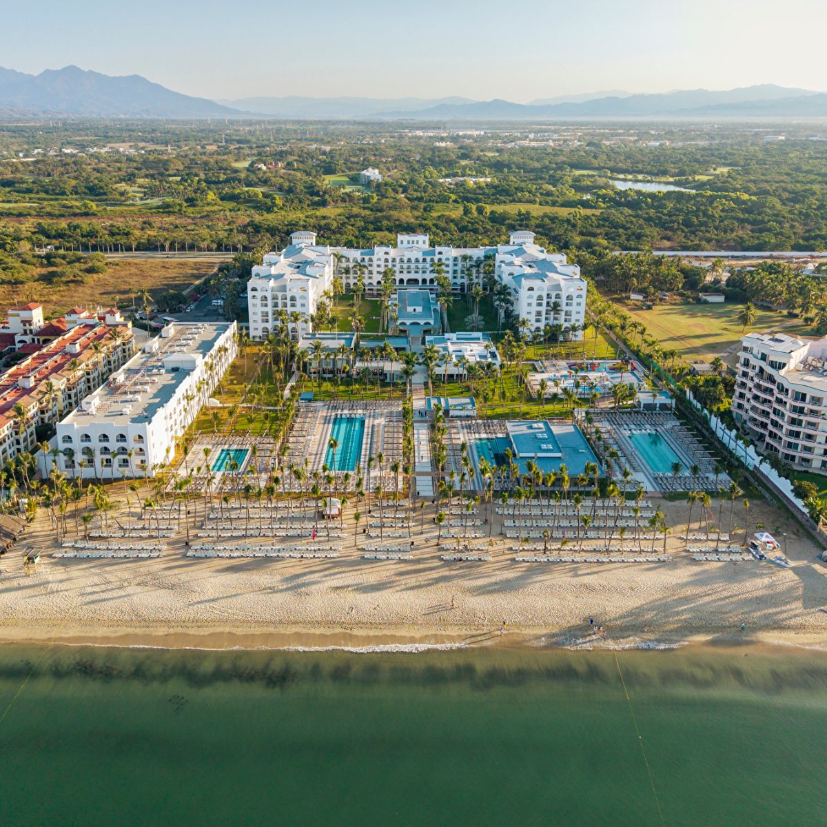 Aerial view of Hotel Riu Flamingos, perfect for a destination wedding, with pools and palm trees by the ocean.