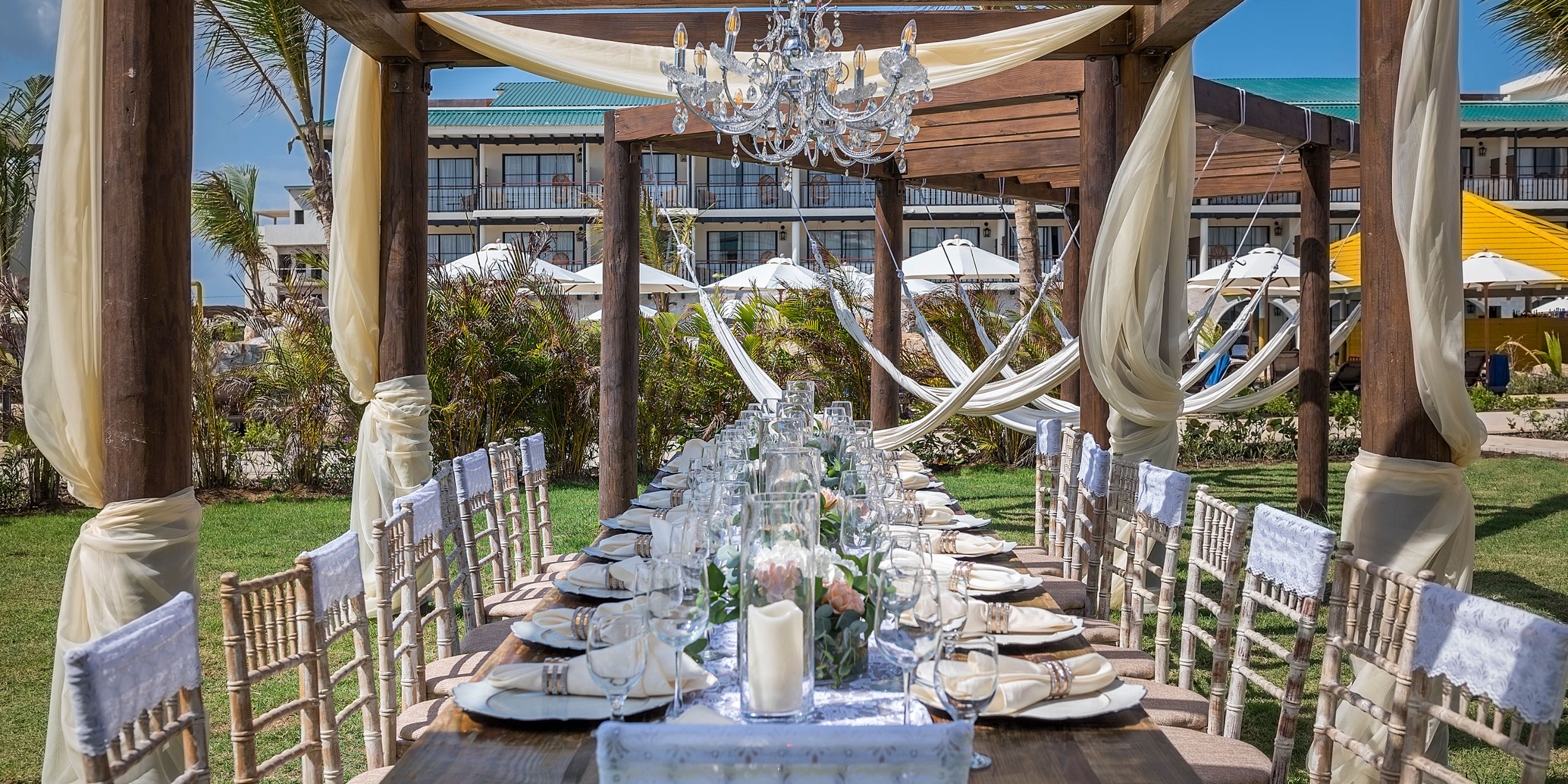 El Beso at Ocean El Faro: elegant outdoor banquet table for a destination wedding under a pergola.