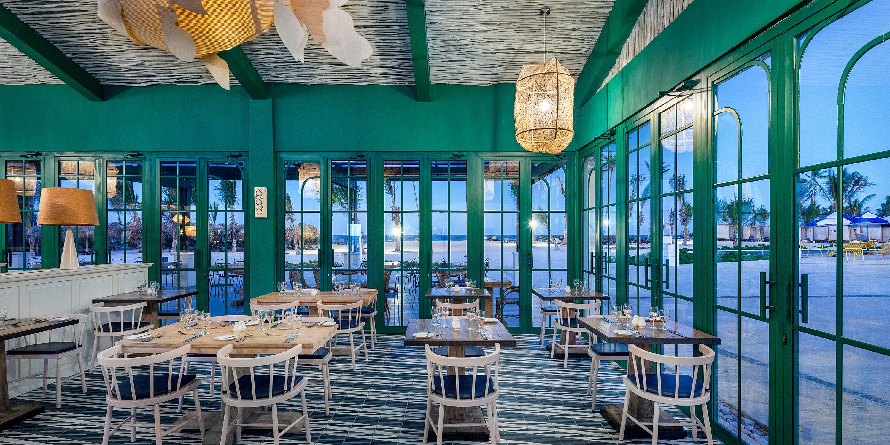 El Beso at Ocean El Faro: ideal beach restaurant with green walls, straw lights, and ocean views for weddings.