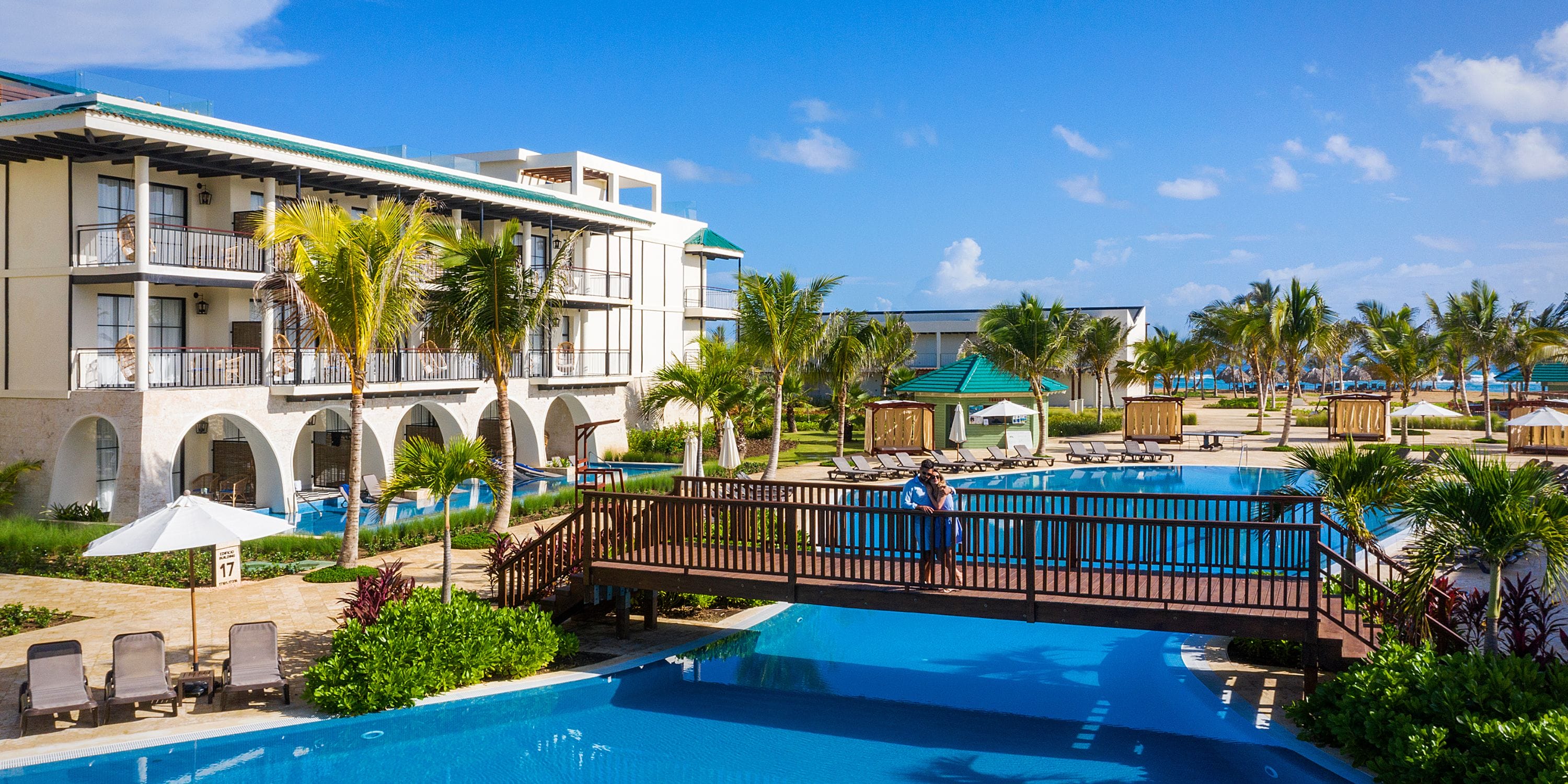El Beso at Ocean El Faro offers a pool, wooden bridge, and palms—perfect for a destination wedding.