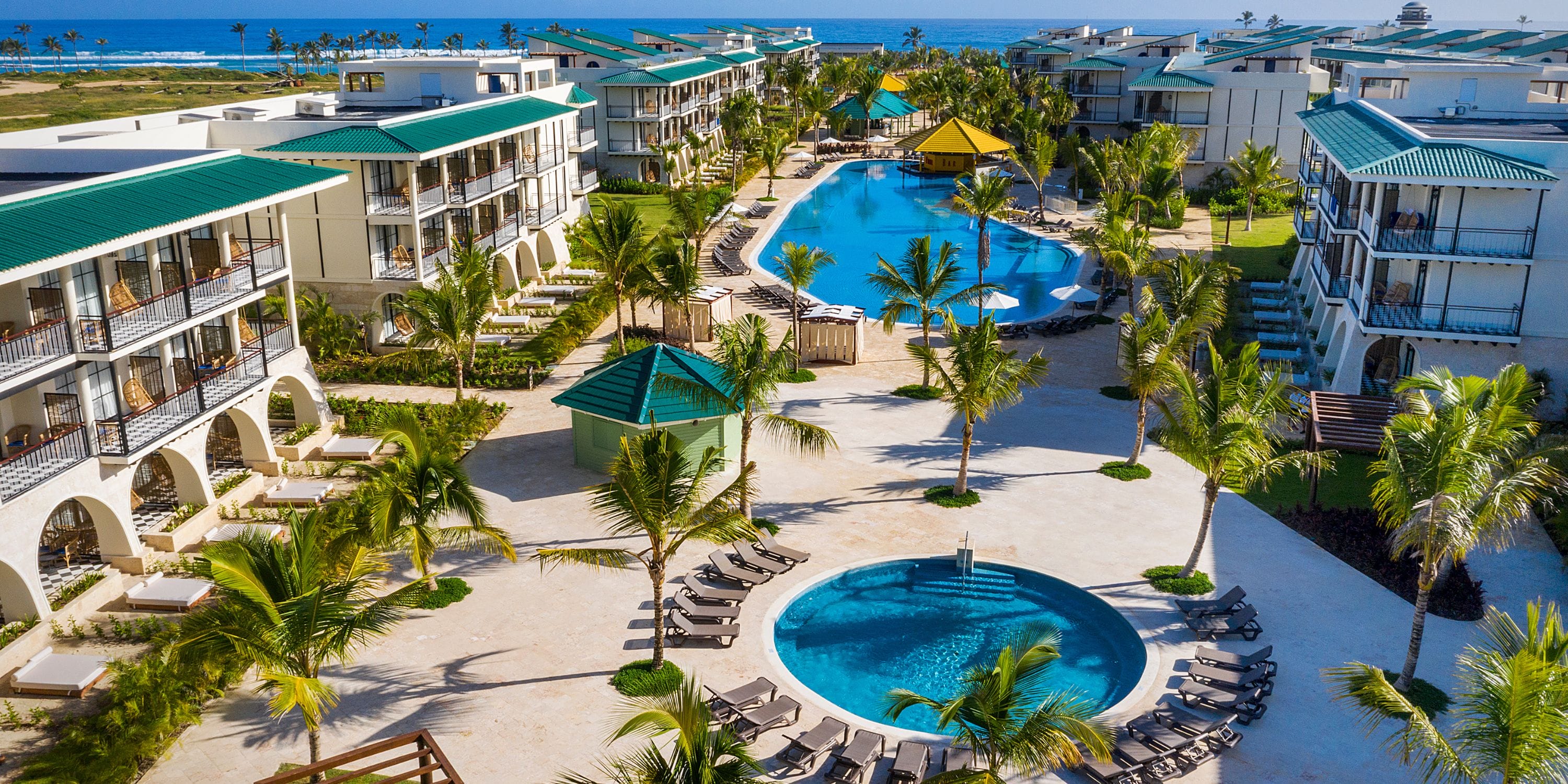 Aerial view of El Beso at Ocean El Faro, a stunning destination wedding spot with pools and palms.