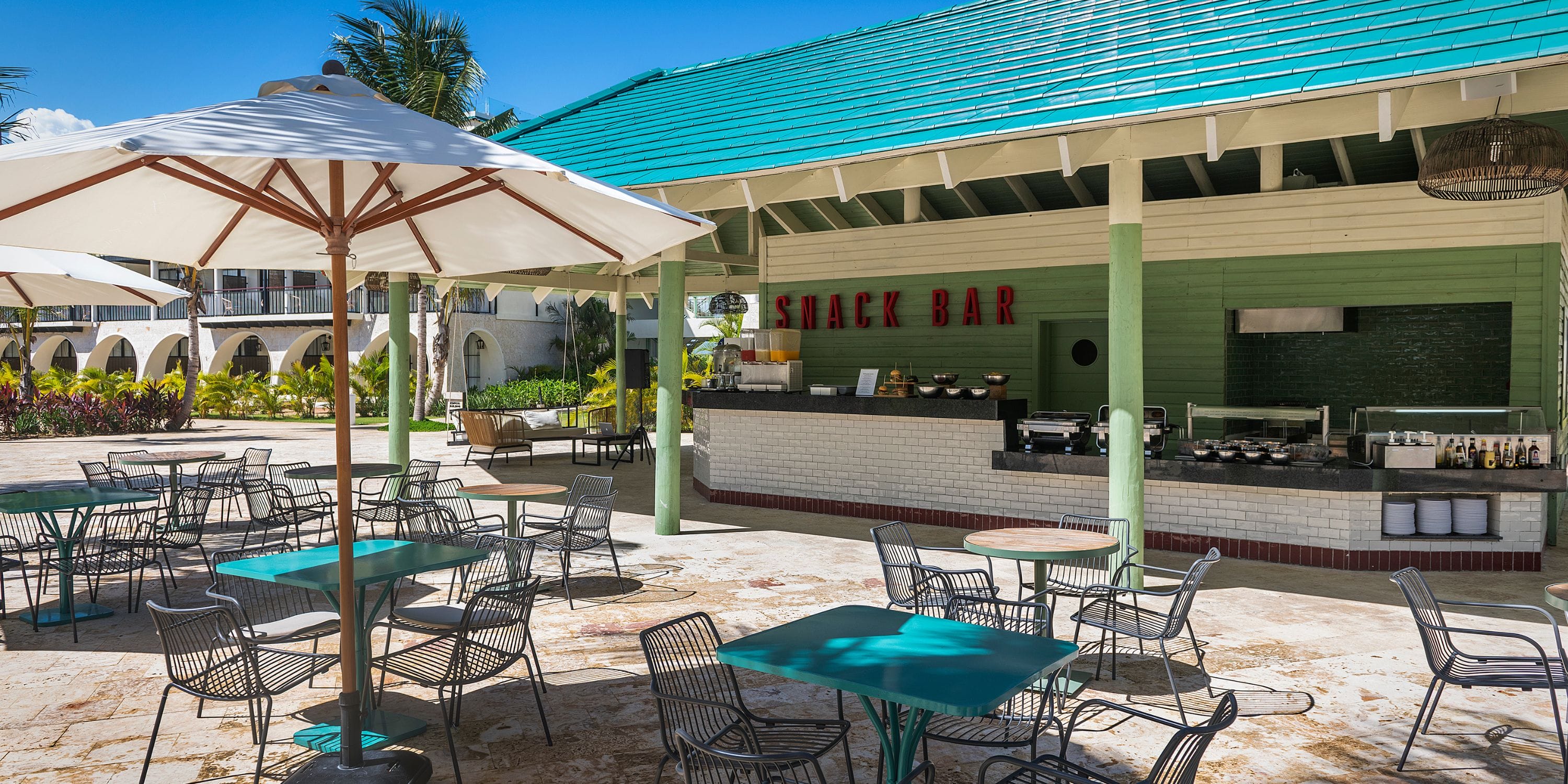 El Beso at Ocean El Faro, perfect for a destination wedding, has teal tables and a green-white pavilion.