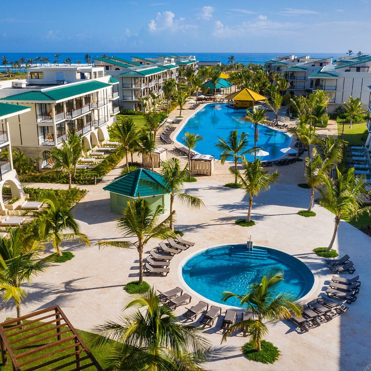 Aerial view of El Beso at Ocean El Faro, a destination wedding spot with pools, palm trees, and loungers.