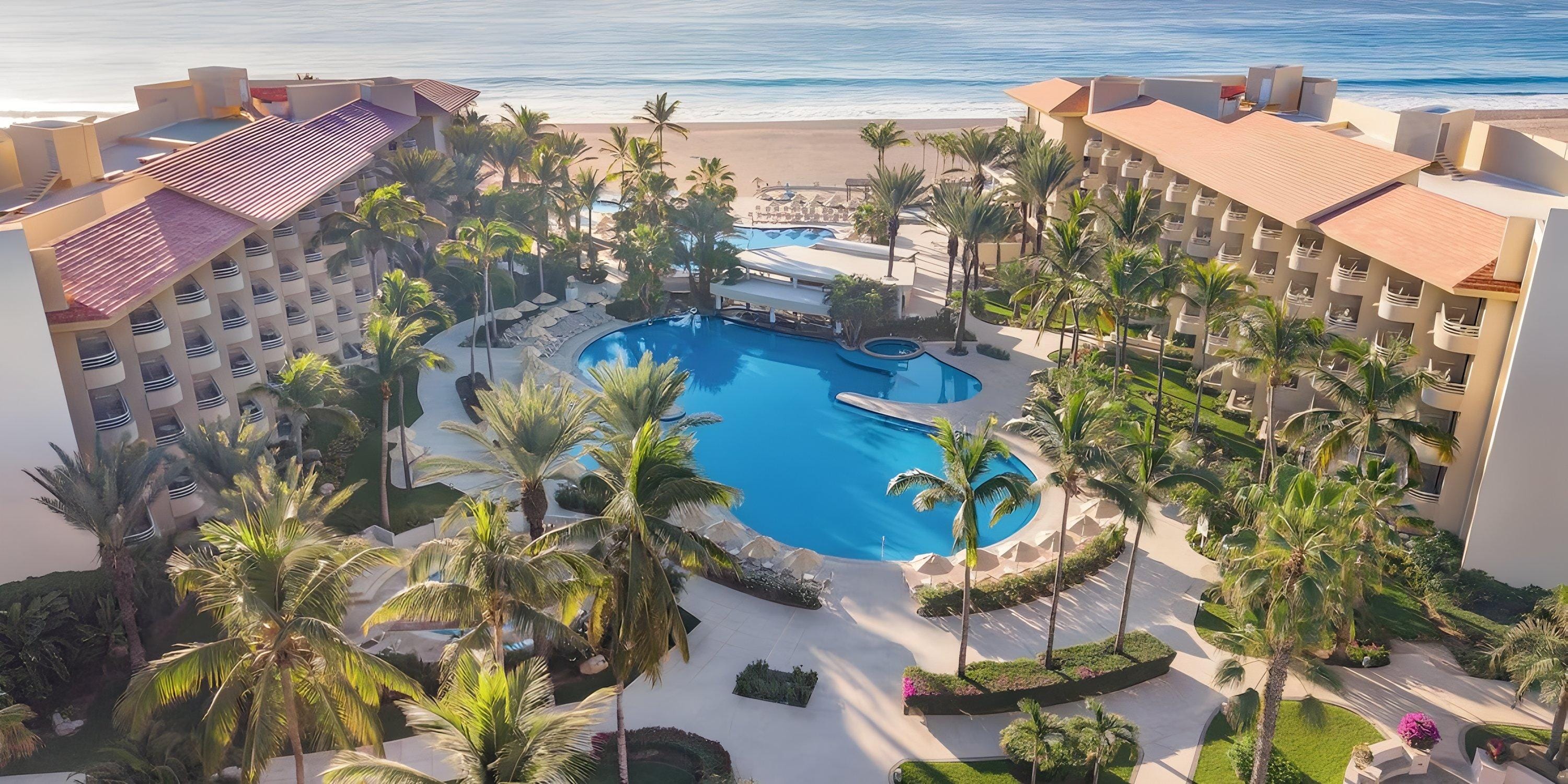 Aerial view of Barceló Grand Faro Los Cabos, a stunning destination wedding spot with pool and palms.