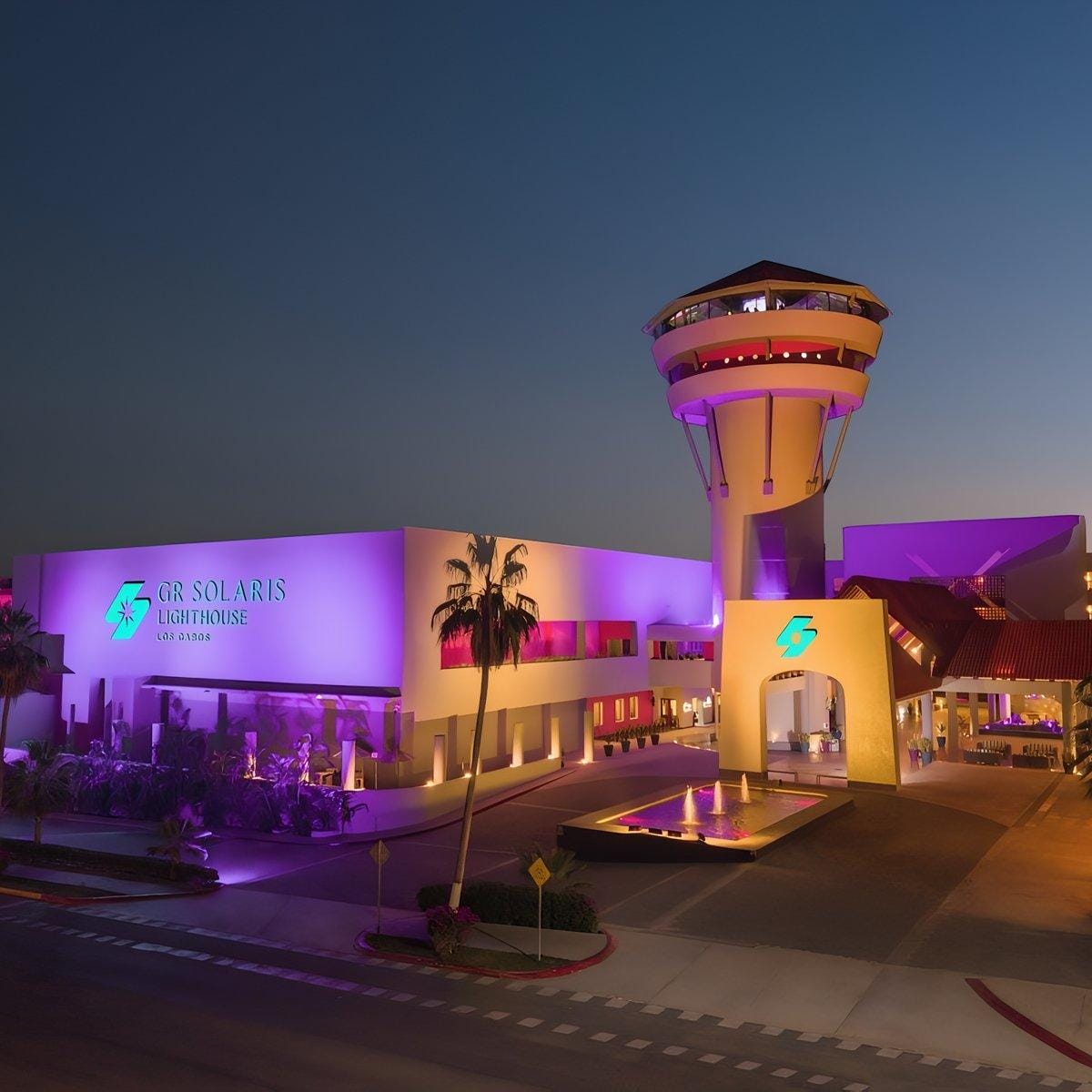 Barceló Grand Faro Los Cabos hotel at dusk, purple lights and tower aglow—perfect for a destination wedding.