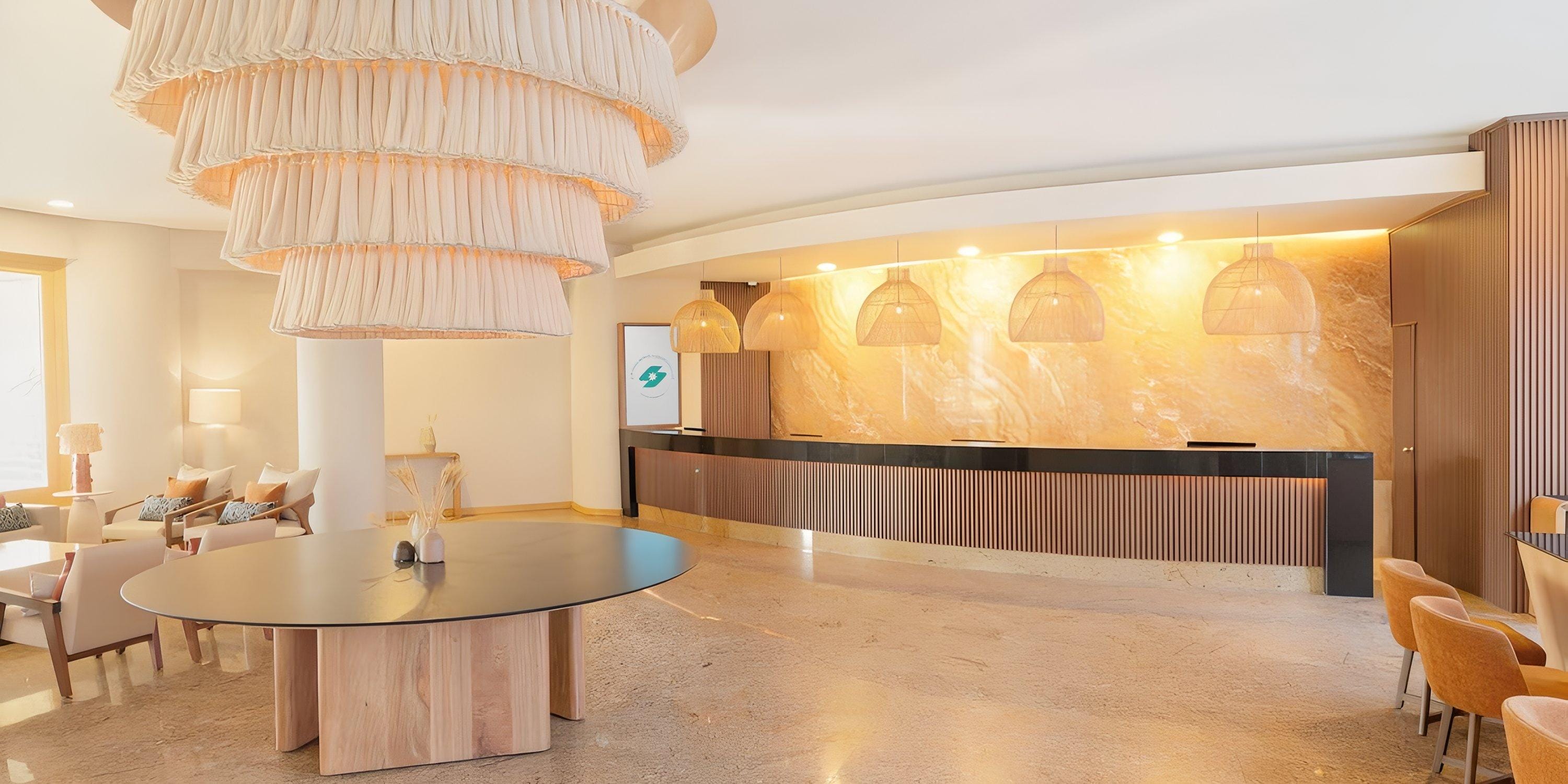 Barceló Grand Faro Los Cabos lobby set for a destination wedding, featuring round table, chandelier, and reception desk.