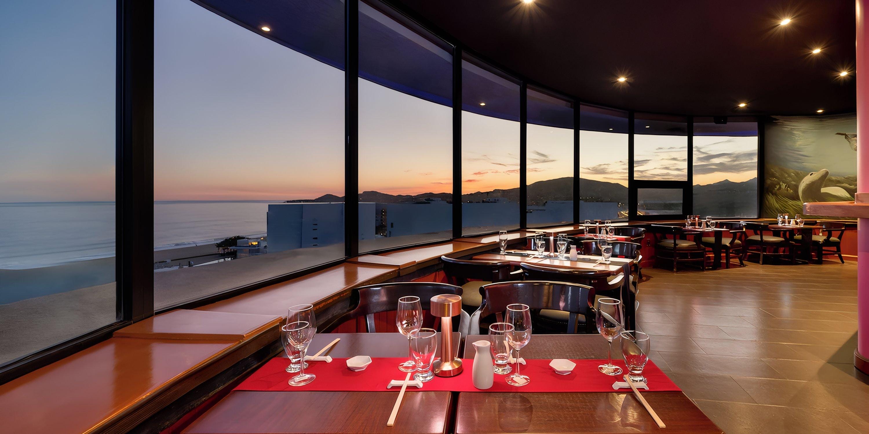Barceló Grand Faro Los Cabos: set tables and large windows with ocean sunset—perfect for a destination wedding.