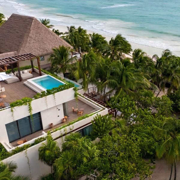 A modern beachfront villa perfect for a destination wedding, rooftop pool, palm trees, and ocean views.