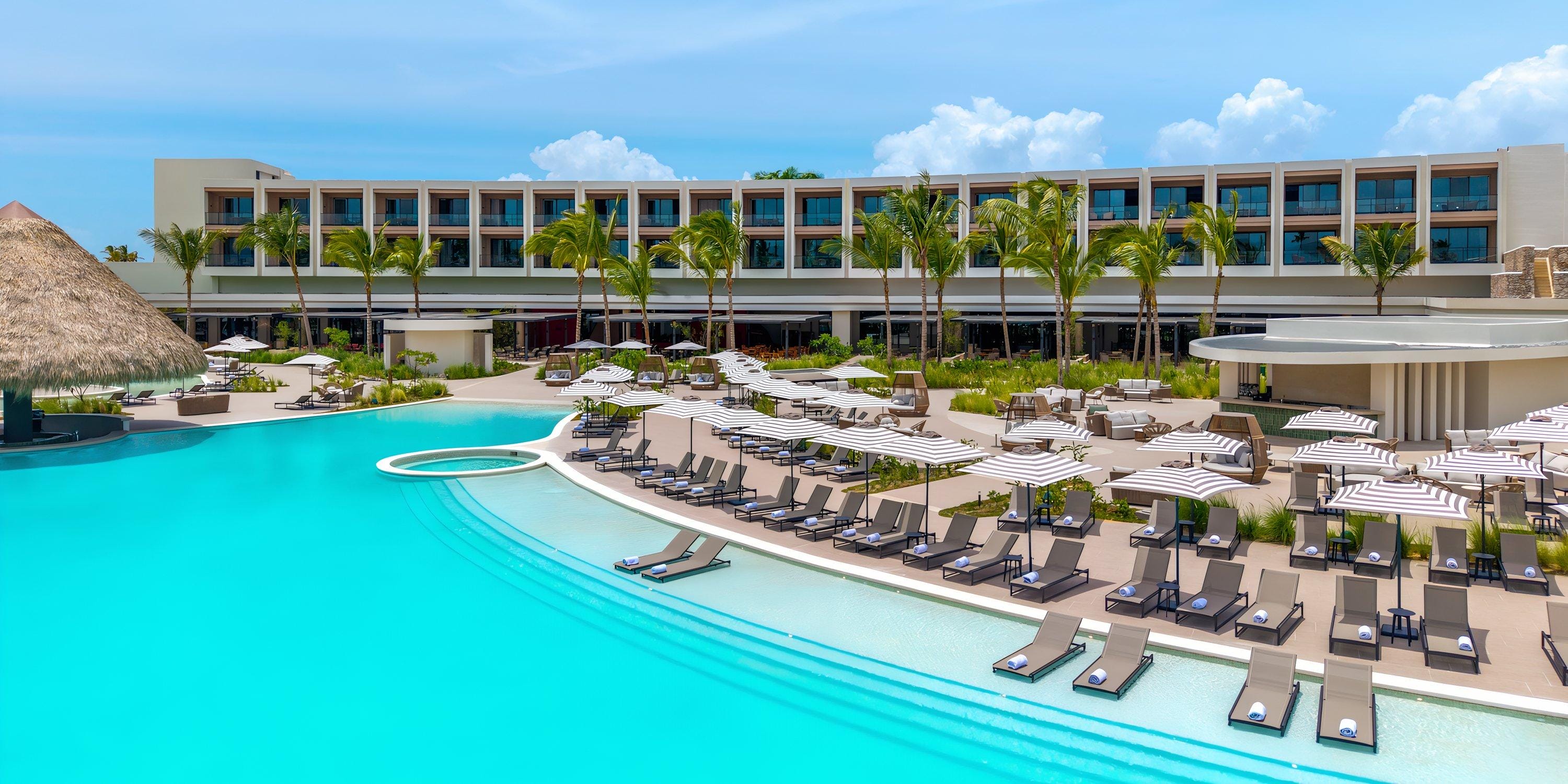Hilton Cancun Mar Caribe: ideal destination wedding spot with a large pool, lounge chairs, and umbrellas.