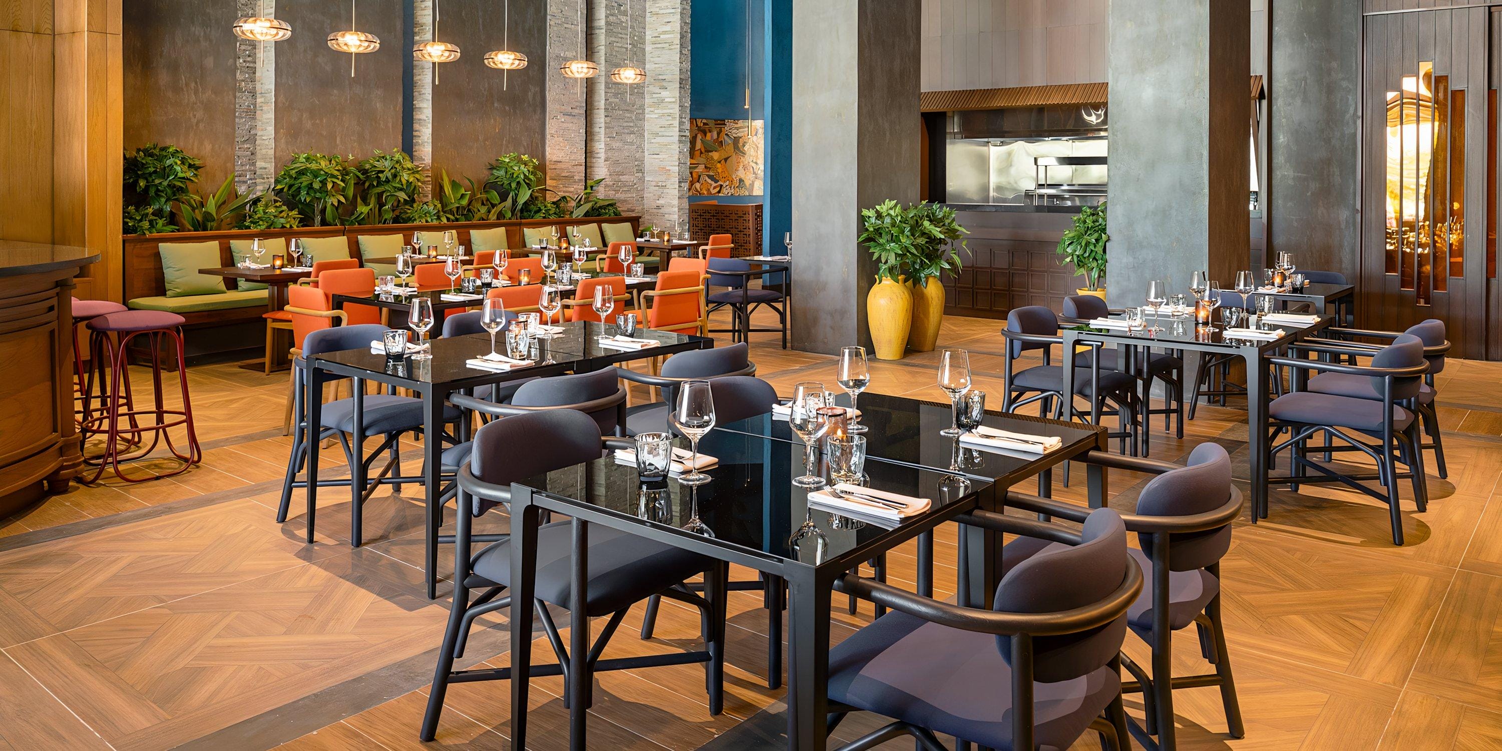 Hilton Cancun Mar Caribe’s modern interior set for a destination wedding, with tables, chairs, and plants.