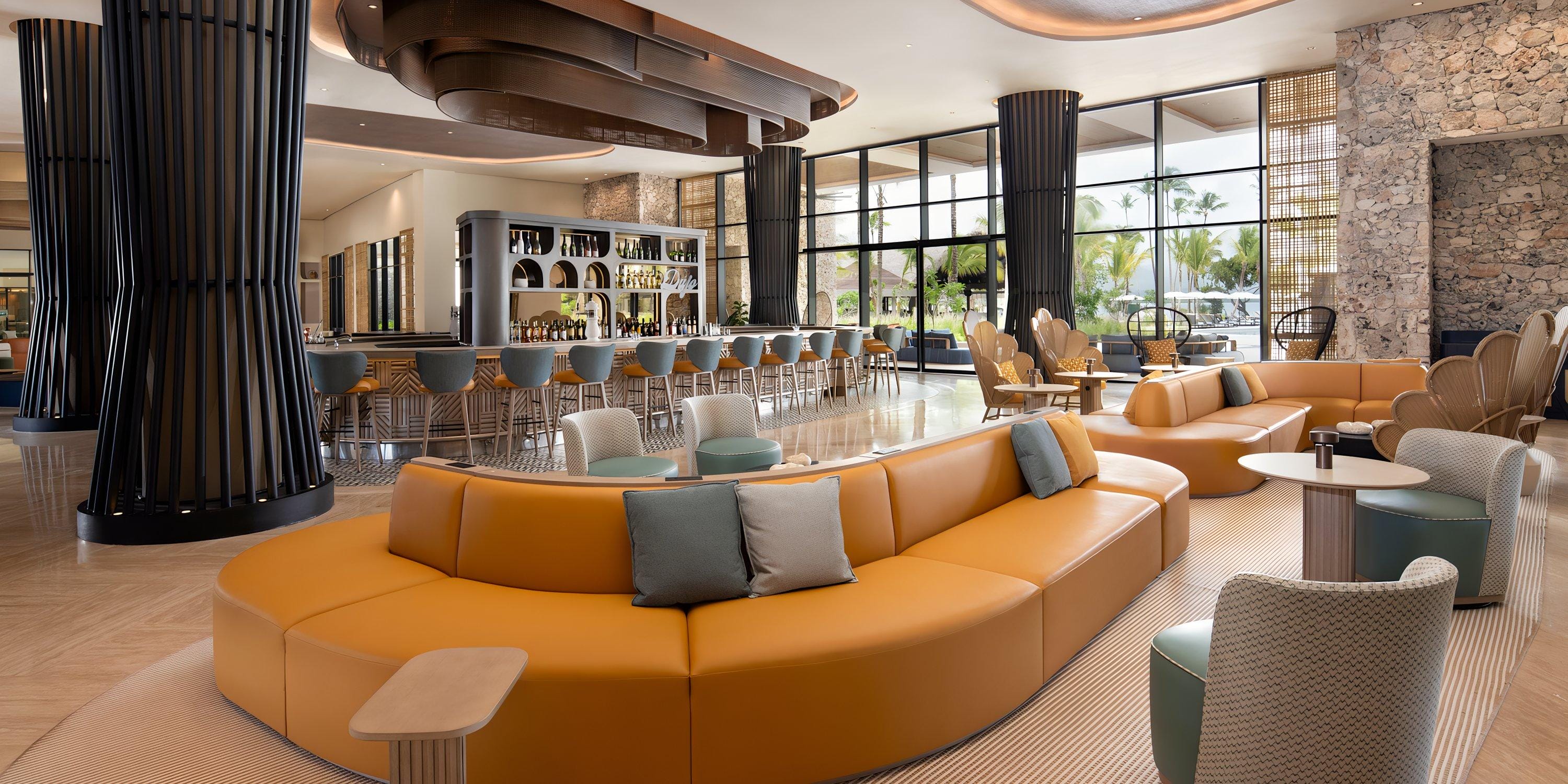 Hilton Cancun Mar Caribe lounge, ideal for a destination wedding, with tan curved sofas and bar seating.