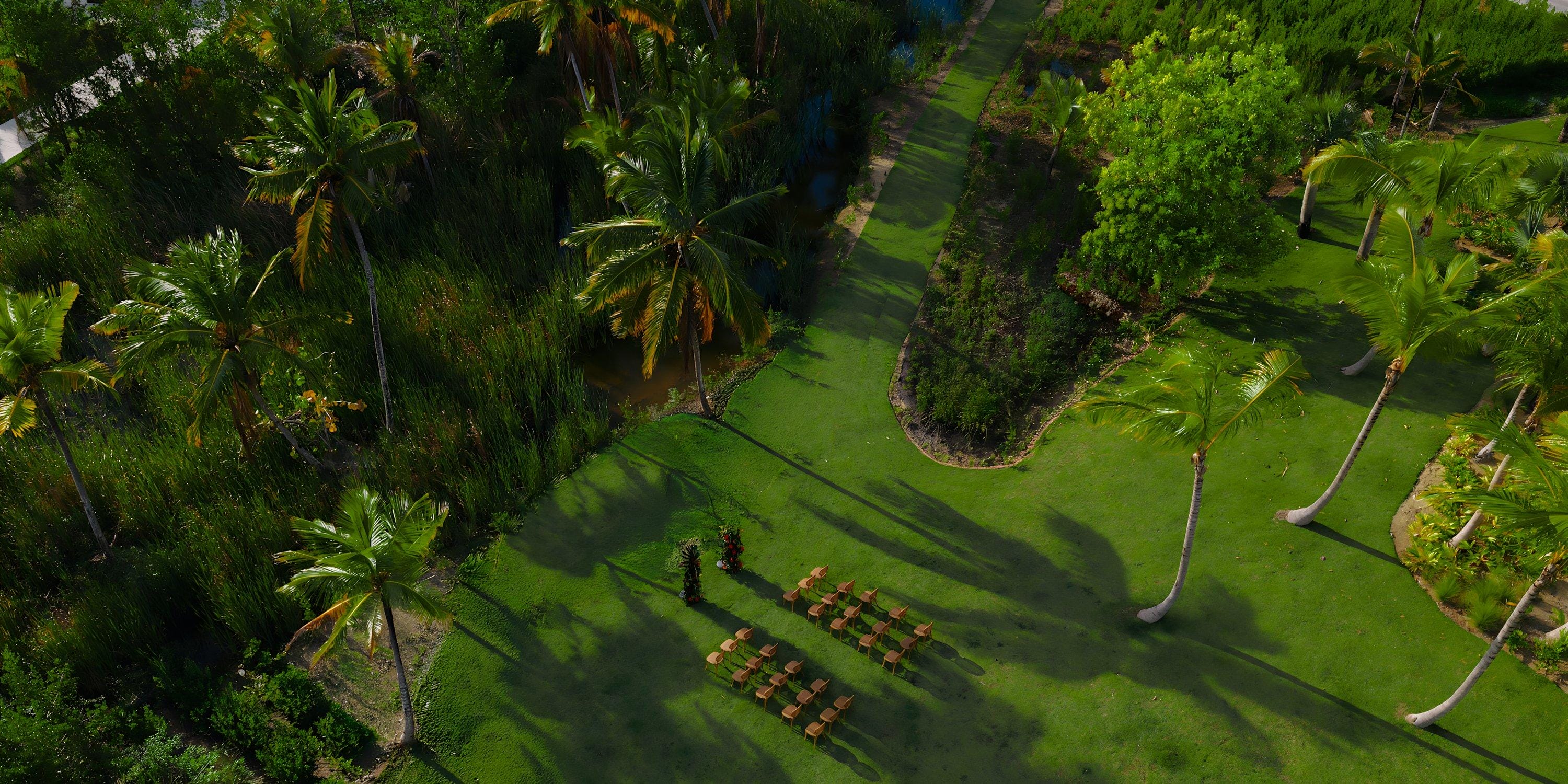 Aerial shot of Hilton Cancun Mar Caribe’s destination wedding setup on a palm-lined grassy lawn.