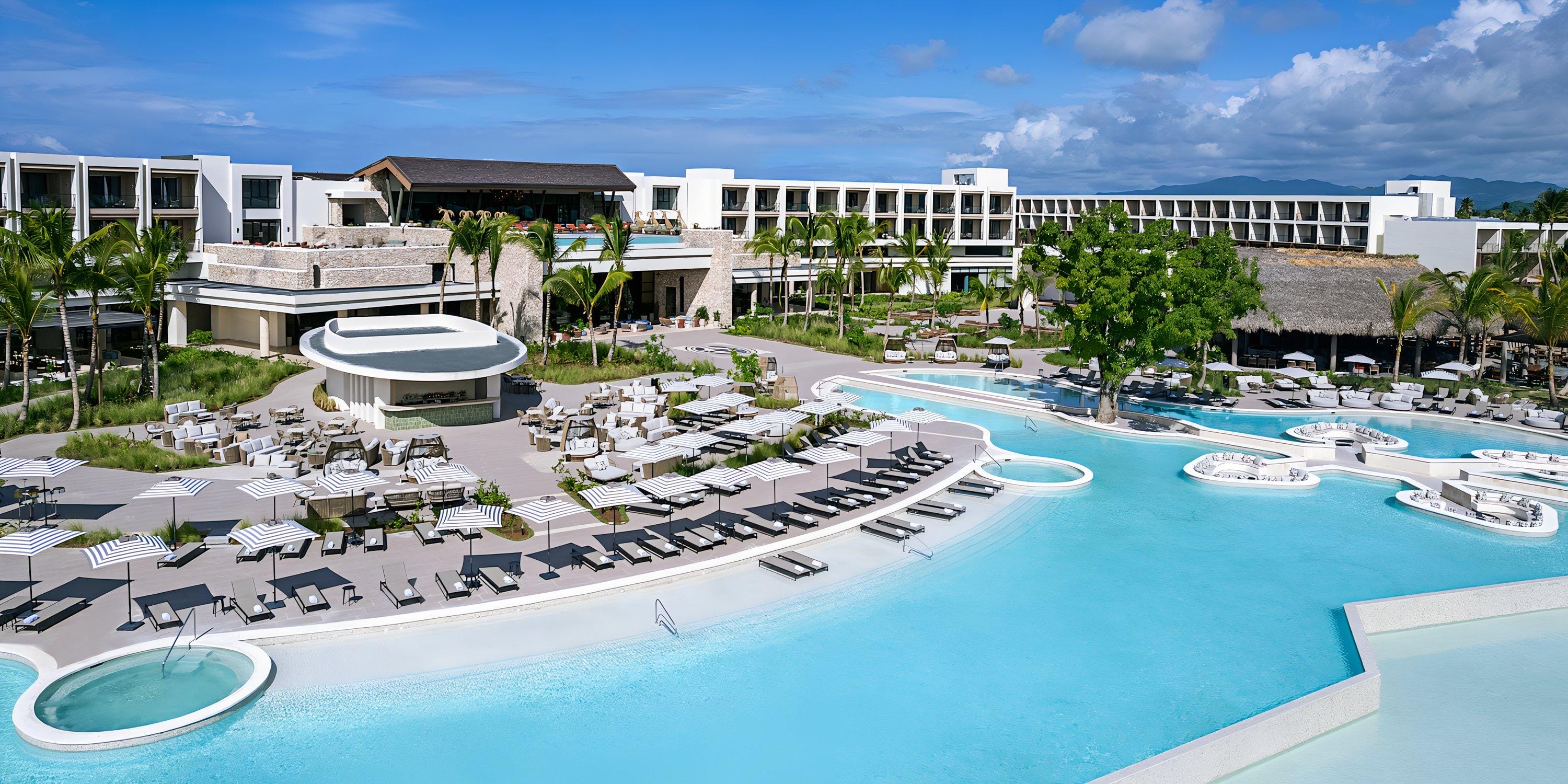 Hilton Cancun Mar Caribe: destination wedding resort with outdoor pool, palm trees, and modern buildings.