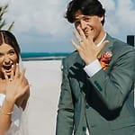 Bride and groom beaming outdoors, showing rings, joyful about destination wedding package prices.