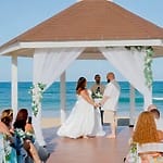 A couple says their vows beneath a beach gazebo at a top Dominican Republic destination wedding.