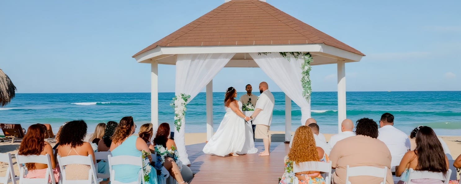 A couple says their vows beneath a beach gazebo at a top Dominican Republic destination wedding.