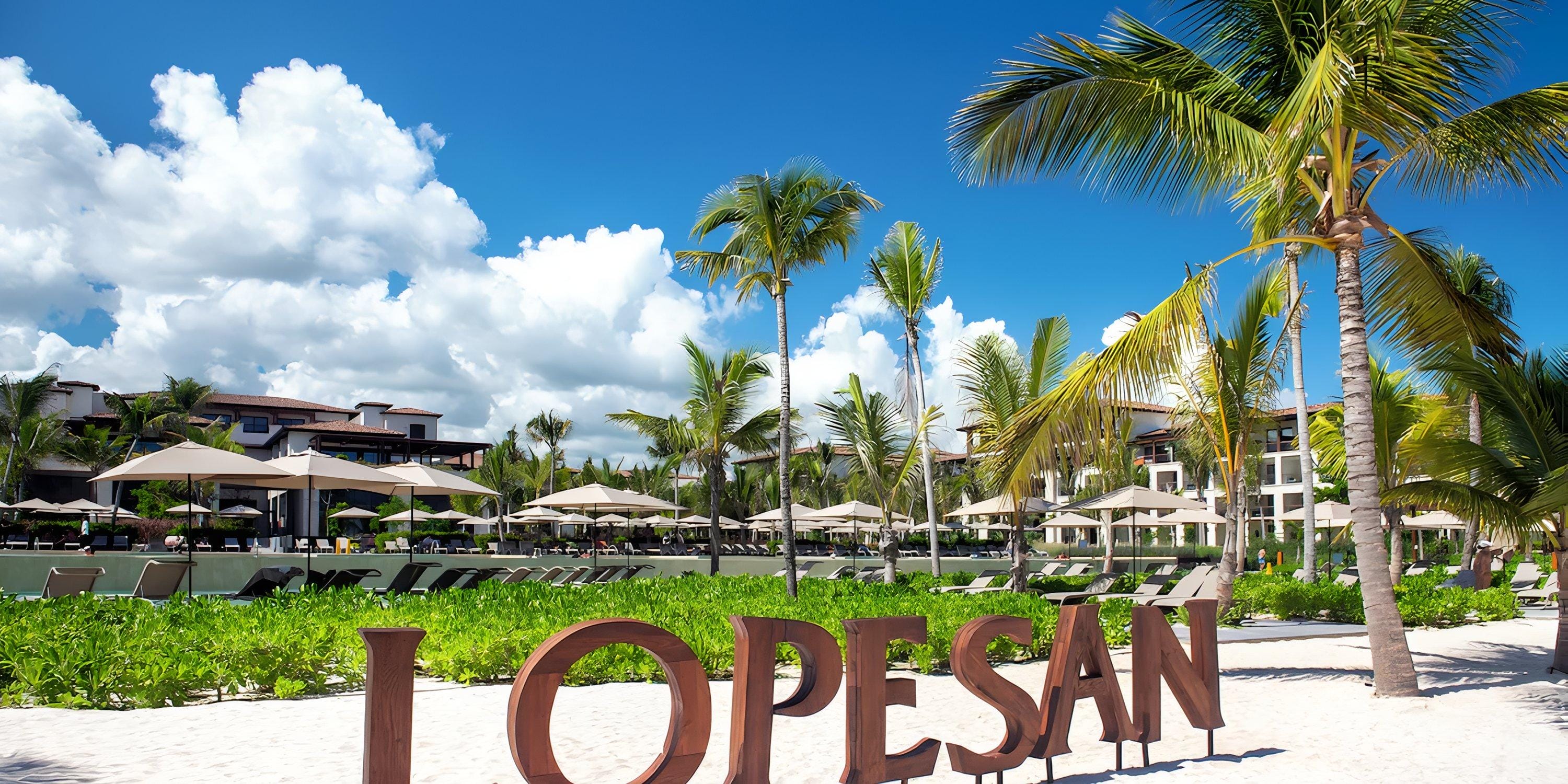 Lopesan Costa Bavaro: beachfront ideal for a destination wedding, with palm trees and lounge chairs.