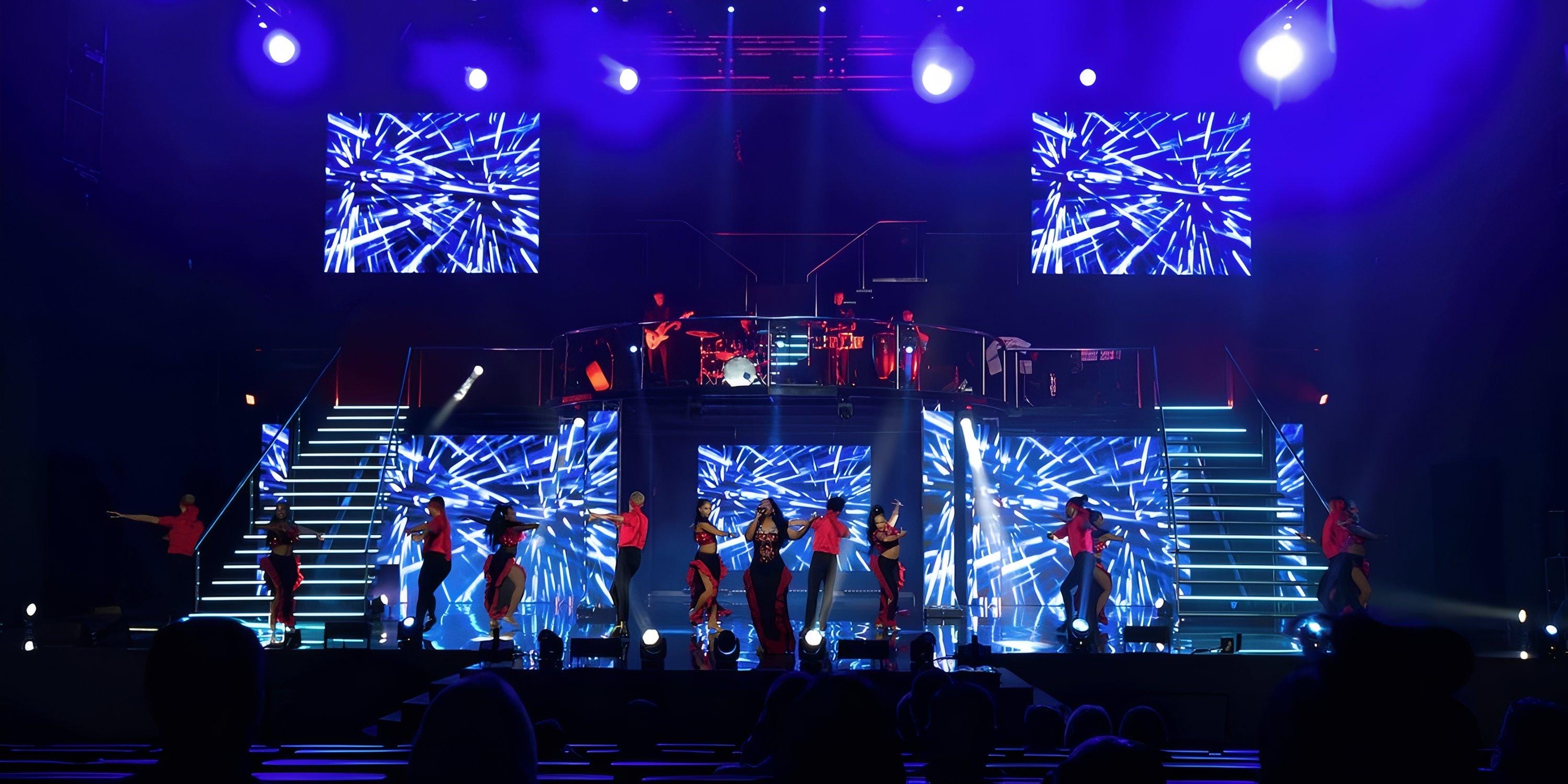 Lopesan Costa Bavaro: dancers and musicians perform with blue geometric lights at a destination wedding.