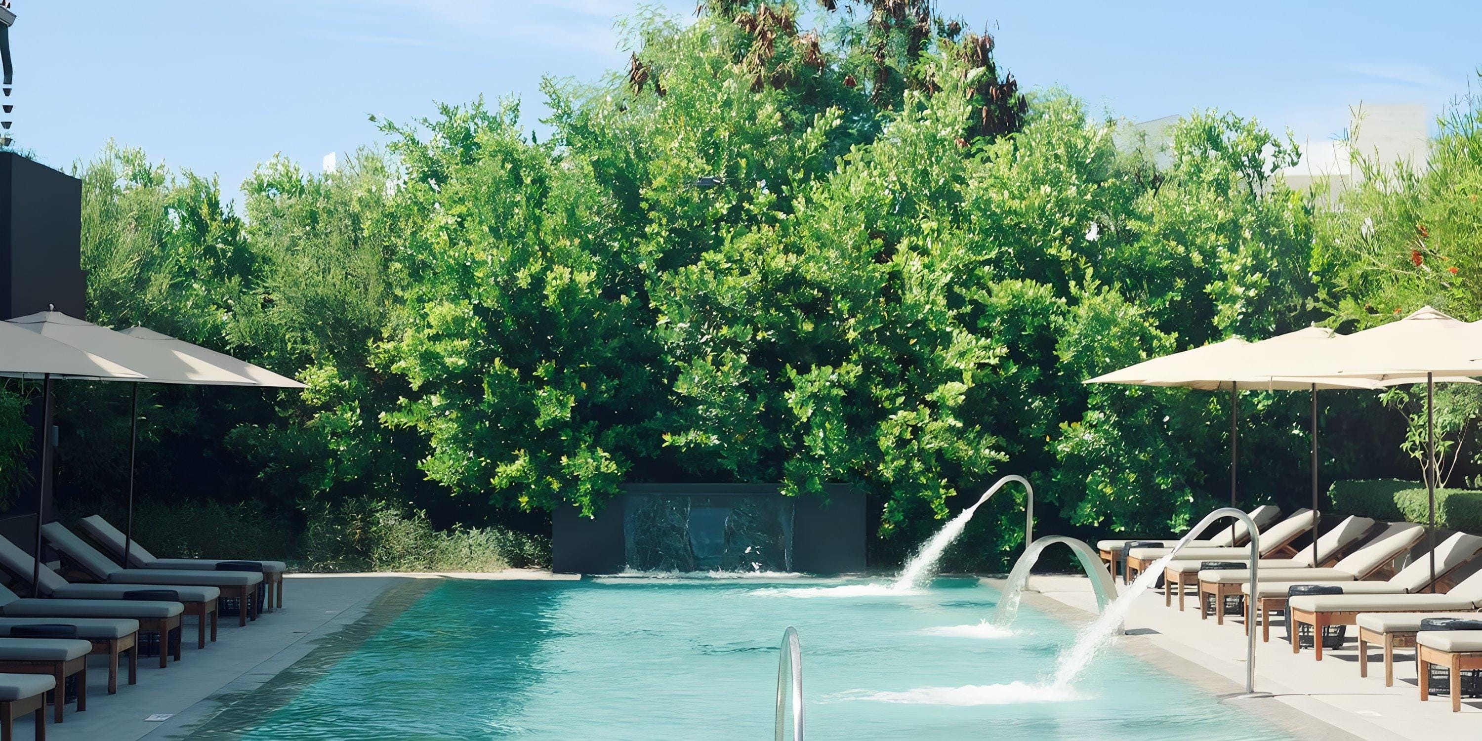 Lopesan Costa Bavaro: Outdoor pool with lounge chairs, umbrellas, and greenery for a destination wedding.