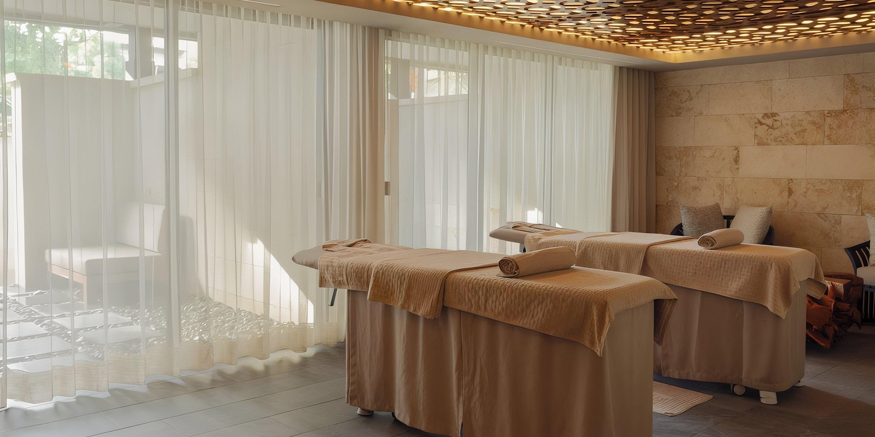 Lopesan Costa Bavaro spa room, ideal for a destination wedding: two massage tables, sheer curtains, soft lighting.