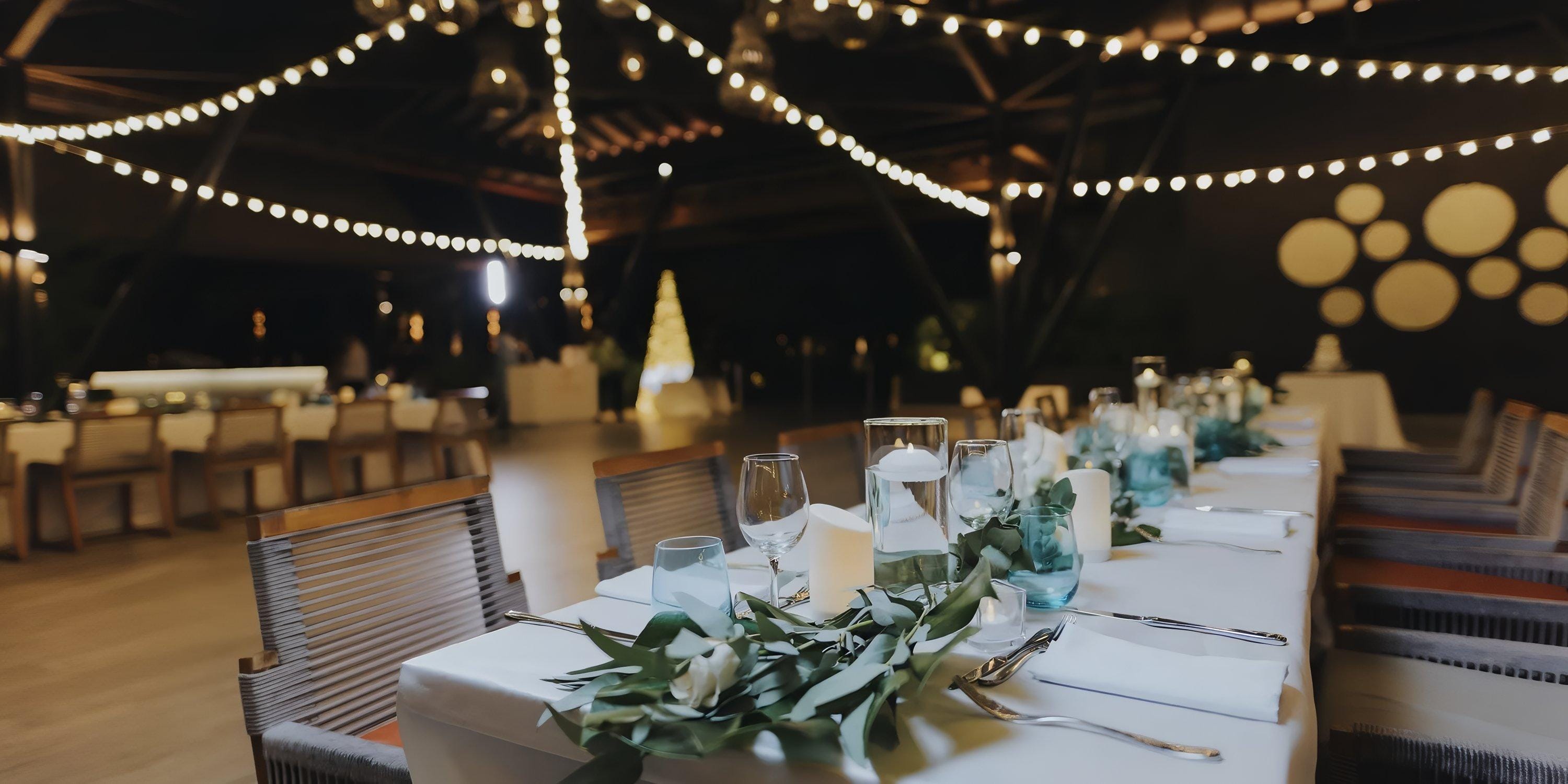 Chic destination wedding table at Lopesan Costa Bavaro with candles, greenery, and indoor string lights.